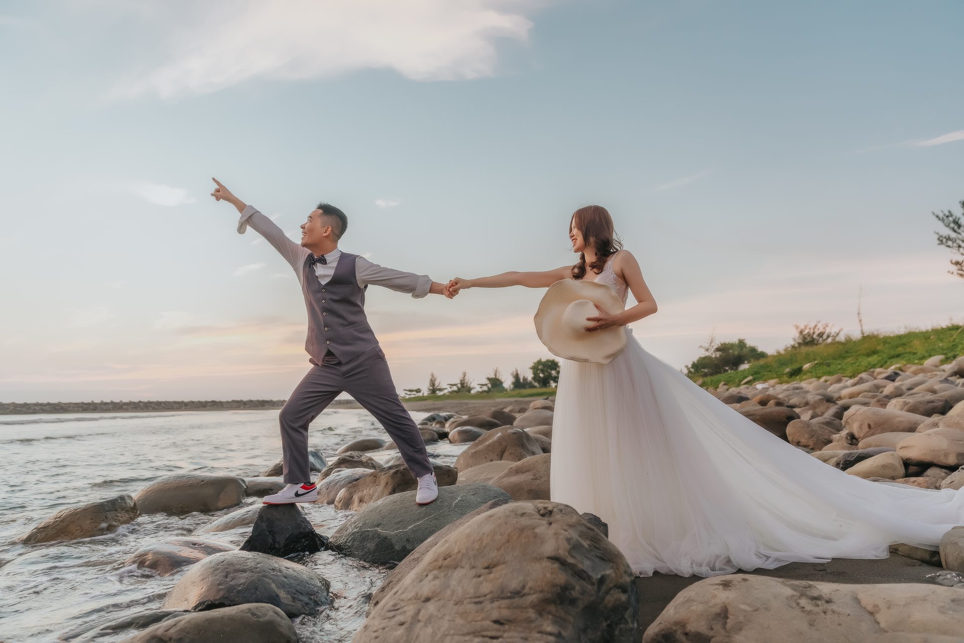 高雄婚紗攝影 海邊石灘俏皮指向遠方