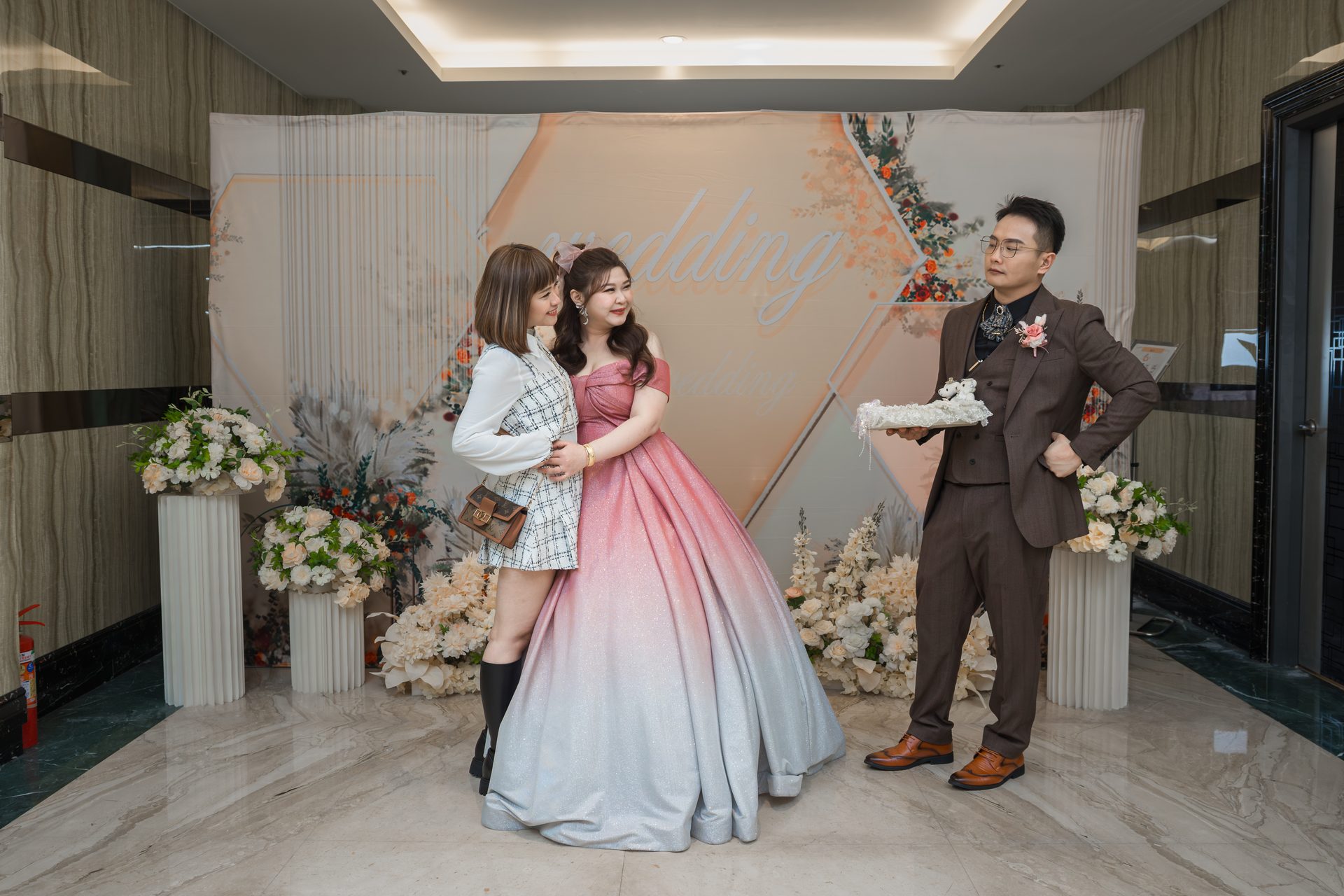 送客時新人於花藝背板前的粉色禮服合影,高雄婚禮攝影